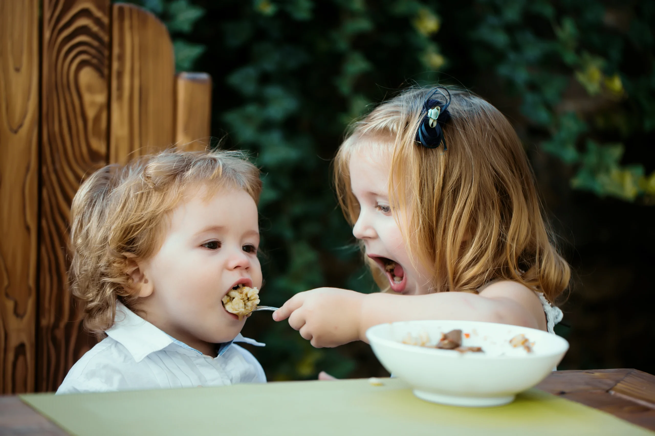 Niños preparando una receta saludable con ayuda de un adulto